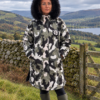 Urban Arctic camo waterproof changing robe with black faux fur hood and hues of olive green, black, white and grey. AI Generated image.